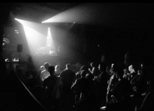 Black-and-white shot of a packed dance floor under spotlights